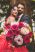 Henna Fotos, Kına Resimleri – Brautstrauß wird vom Brautpaar festgehalten und in die Kamera des Hochzeitsfotografen gehalten. Das Foto ist aus der Froschperspektive aufgenommen. Im Fokus steht der Brautstrauß während das Brautpaar in der Tiefenunschärfe posiert.