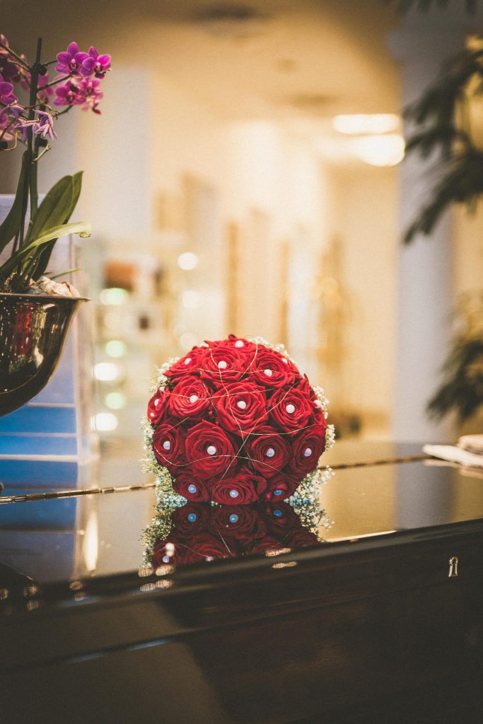 Roter Brautstrauss Bouquet aus Rosen auf Klavier