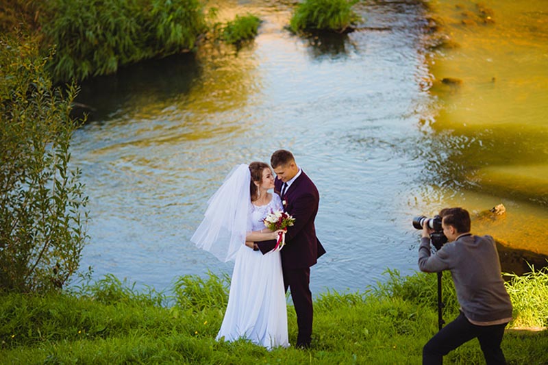 Hochzeitsvideograf filmt Brautpaar am Teich in Köln