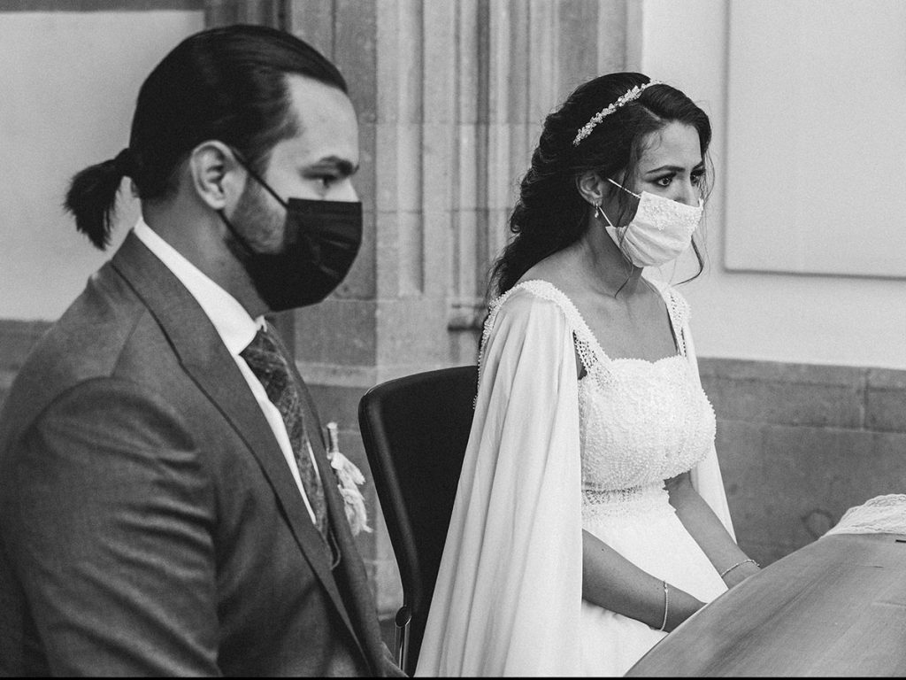 Hochzeit: Braut und Bräutigam sitzen in der Rentkammer Köln und lassen sich trauen mit Maske während Corona-Zeit