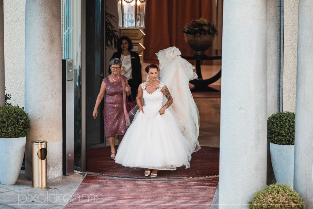 Hochzeit Fotograf belichtet Braut beim verlassen des Ressort. Erster Antritt kurz vor der Trauung.