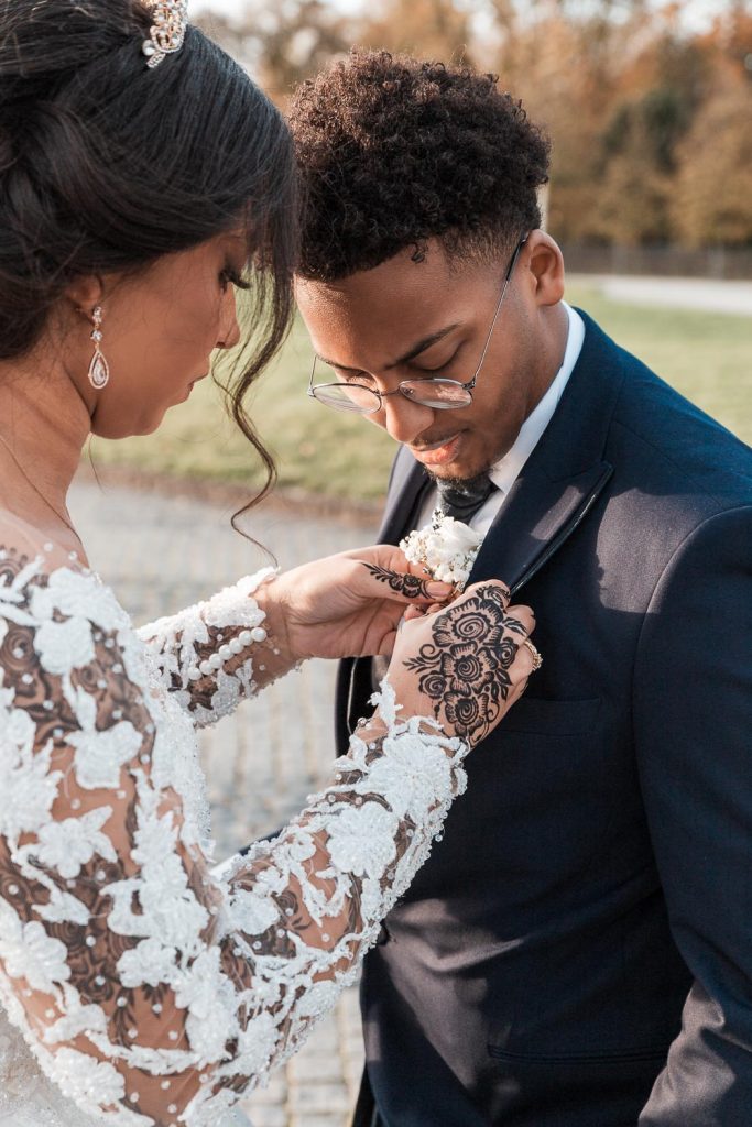 Hochzeitsfotograf Bruehl Schloesser - somalisch afrikanisch hochzeit - Hochzeitsreportage_6_Brautpaar-Shooting-Braut steht Bräutigam die Ansteckblume an