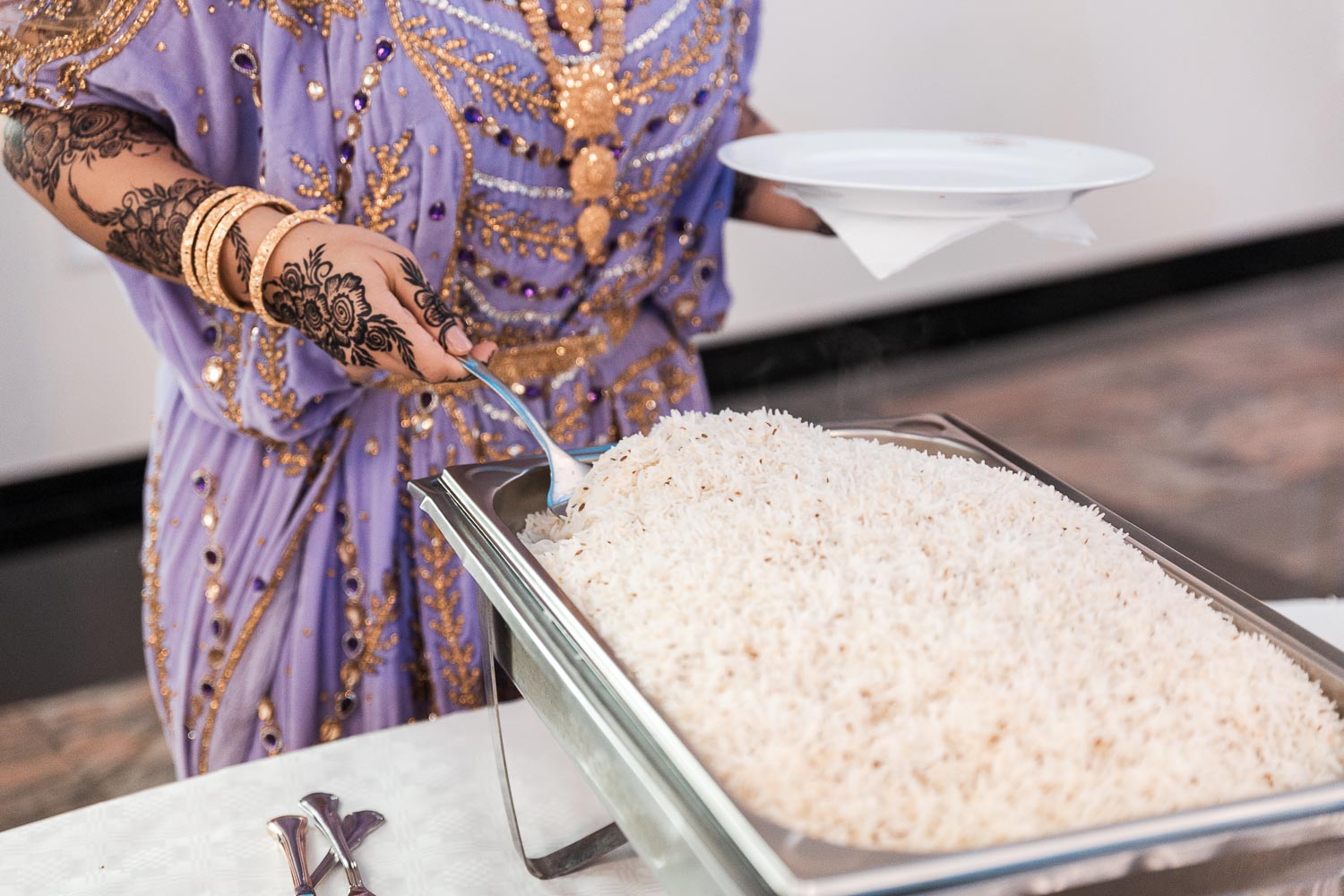 Somalische Braut schenkt sich Reis ein vom Buffetisch im Event Palast in Köln Hürth