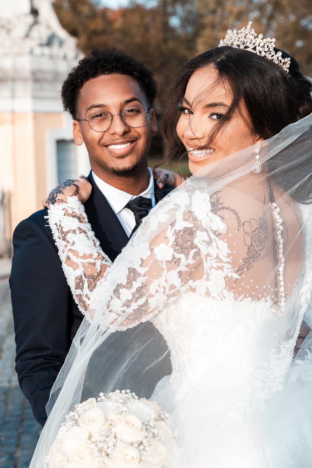 Braut mit Diadem umarmt Bräutigam, somalischer Bräutigam hat schöne weiße Zähne