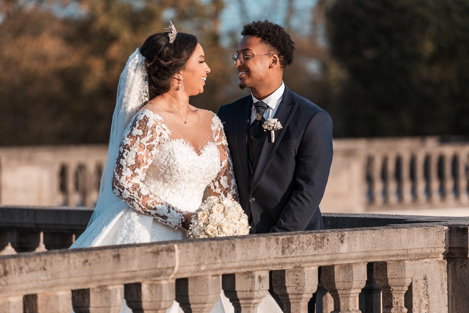 Somalisches Brautpaar posiert am Schloss Brühl hinter einem Geländer für den Hochzeitsfotografen