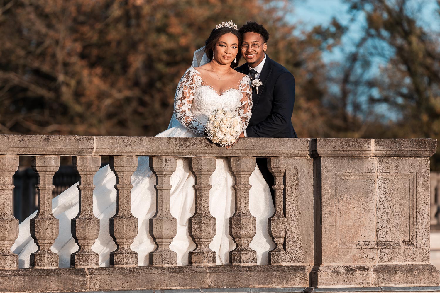 Somalisches Brautpaar posiert am Schloss Brühl hinter einem Geländer für den Hochzeitsfotografen