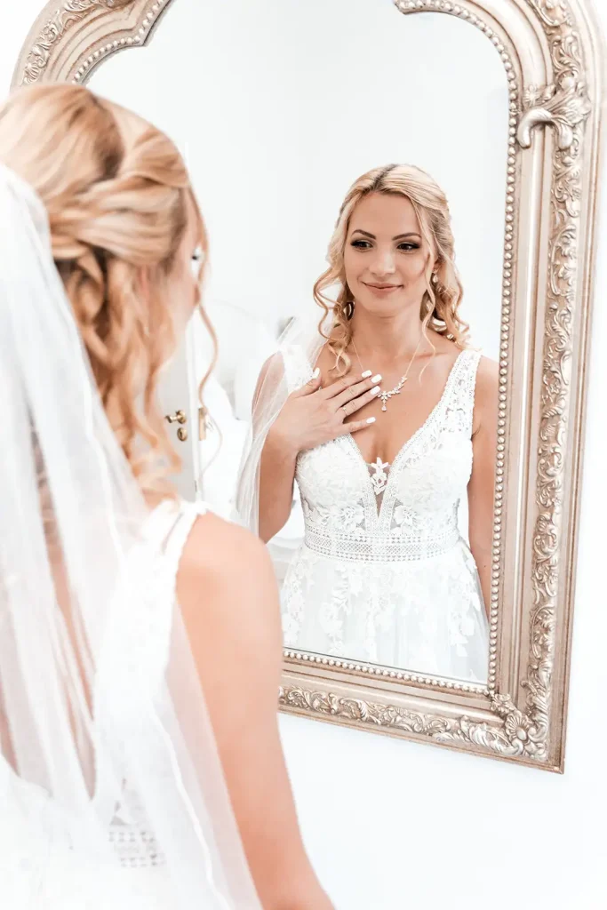 Braut betrachtet sich nach dem Getting Ready im Spiegel vor ihrer Hochzeit auf Schloss Burgbrohl