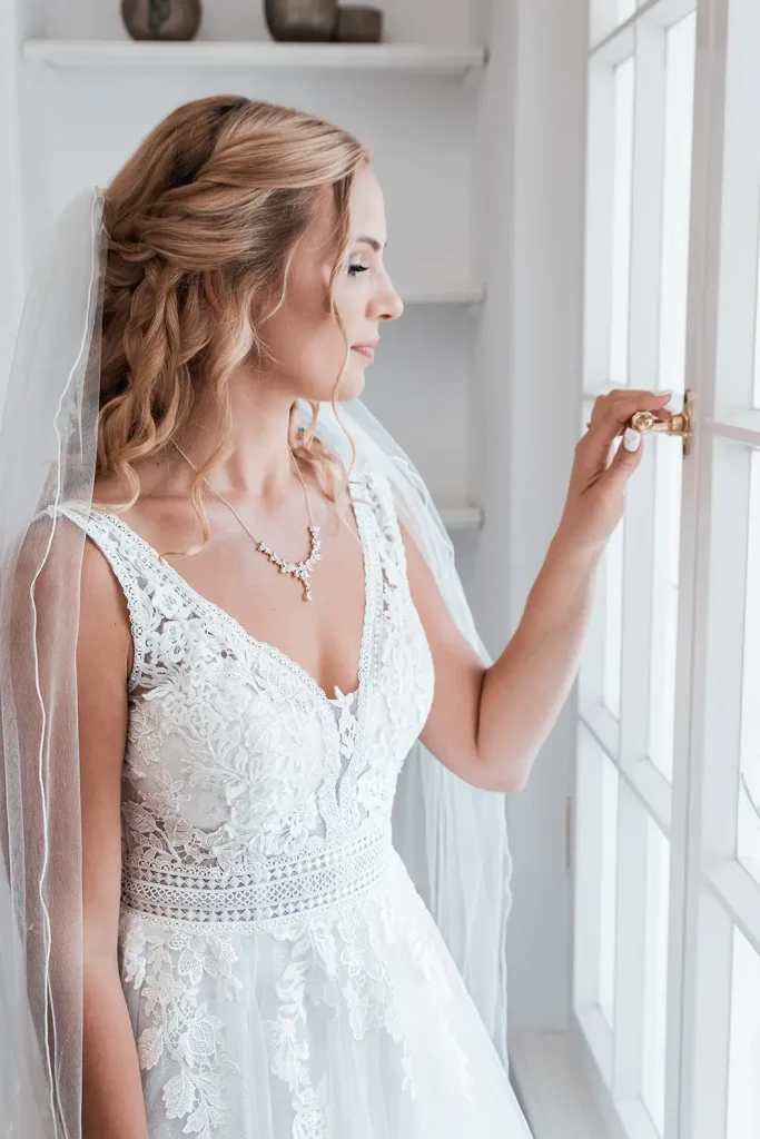 Brautporträt am Fenster mit natürlichem Tageslicht vor der Hochzeit auf Schloss Burgbrohl