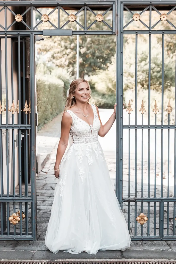 Braut im Hochzeitskleid am historischen Tor von Schloss Burgbrohl