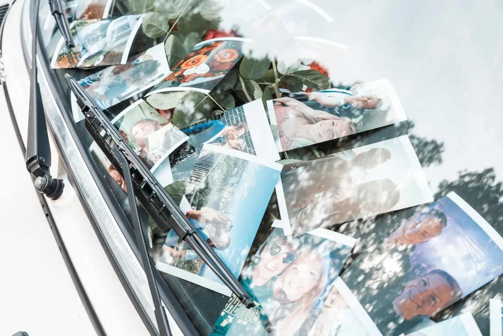 Persönliche Erinnerungsfotos und Rosen als Überraschung am Hochzeitsauto für das Brautpaar