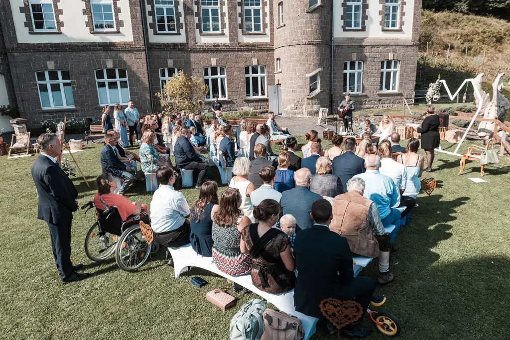 Freie Trauung mit Brautpaar und Hochzeitsgästen im Außenbereich von Schloss Burgbrohl