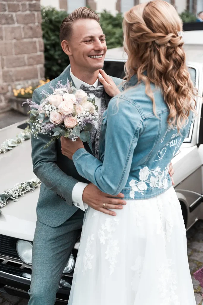 Brautpaar mit Brautstrauß vor dem klassischen Hochzeitsauto bei Schloss Burgbrohl